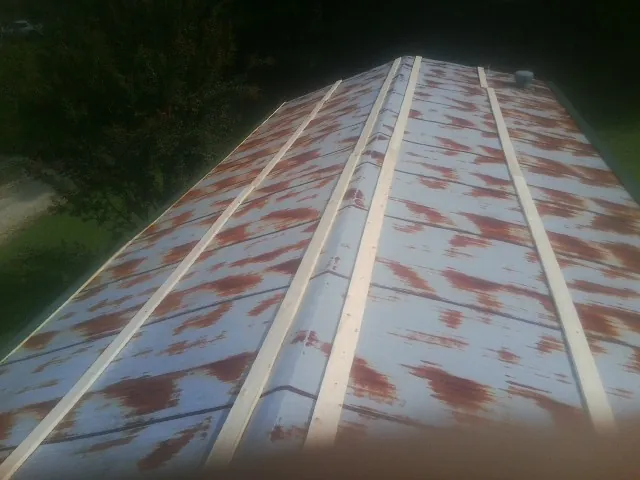 Rusted metal roof panels with new wood purlins before replacement — Storm Damage Roof Repair in Port Jefferson by Roofing Brothers