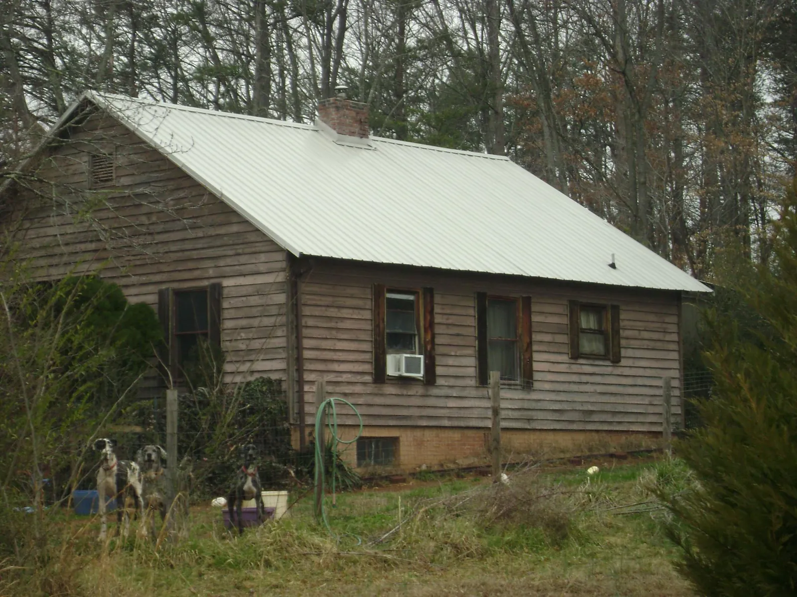 White metal roof on an old wood sided farmhouse, from a Metal Roof Installation job in Port Jefferson